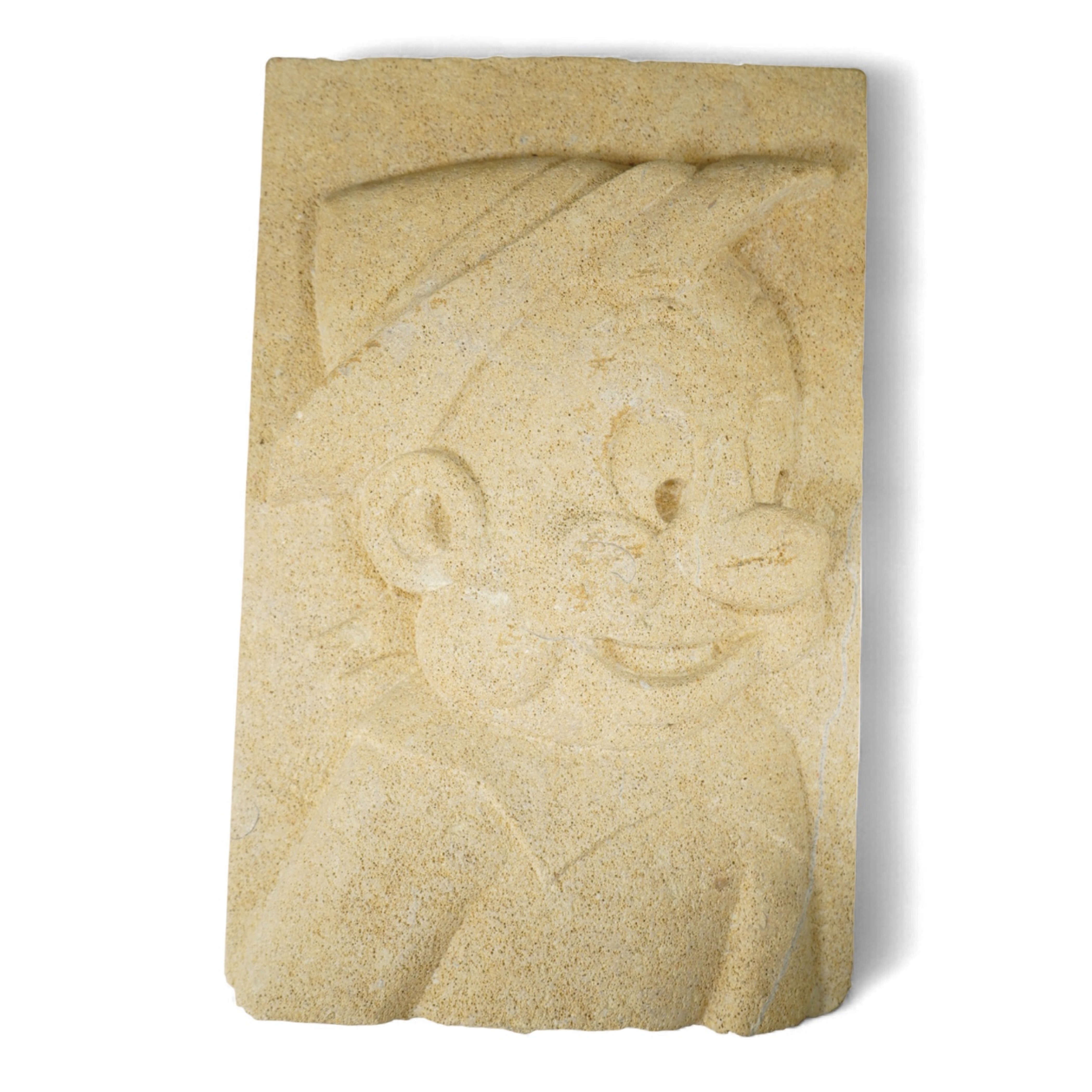 A rectangular carved sandstone panel depicting Pinocchio (Provenance, formally from the façade of Thomas Biles stonemasons building, Corn street, Whitney, Oxon, 1868-1957)